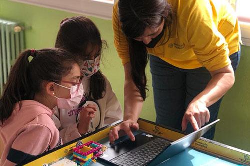 Profesora enseñando a niñas a programar
