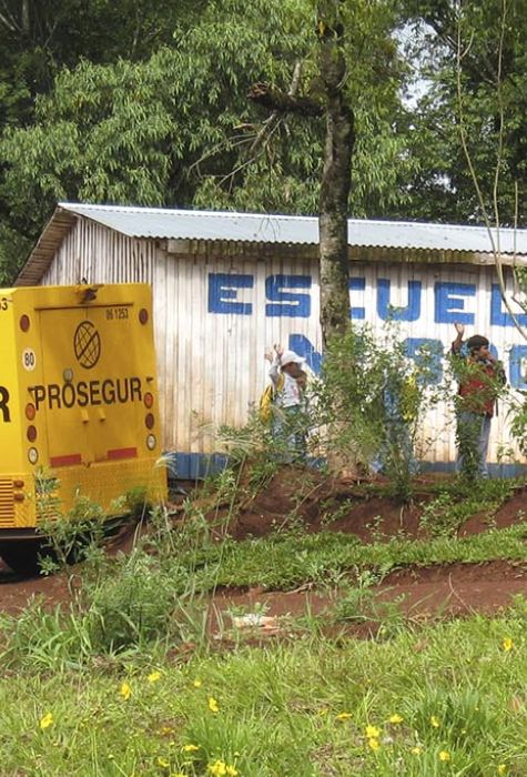 Furgón Prosegur estacionado al lado de una escuela con niños