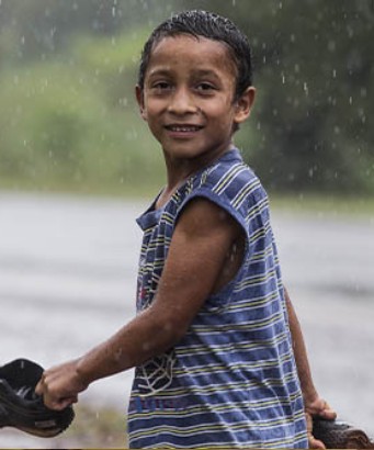 Niño caminando baja la lluvia